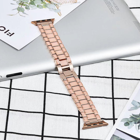 Rose gold watch strap on a white surface with a grid pattern