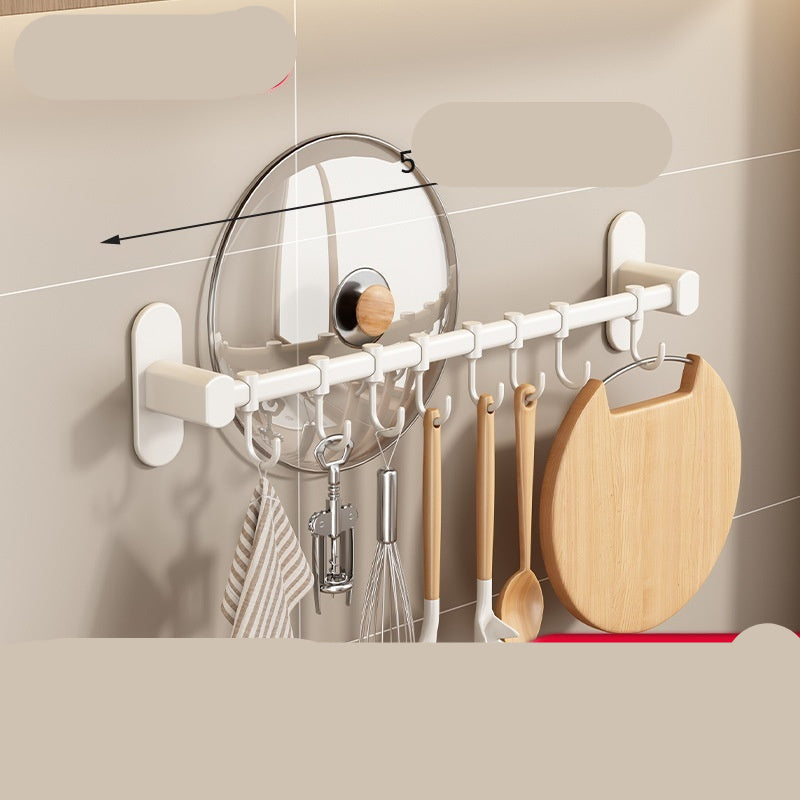 Wall-mounted hook system with various kitchen utensils on a neutral background