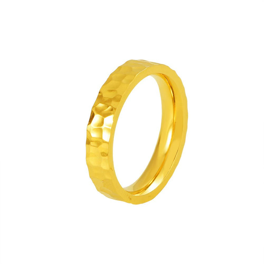 Gold ring with a textured design on a white background
