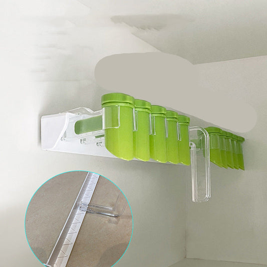 Green spice rack with numbered containers on a white wall, showing close-up of adhesive strip.