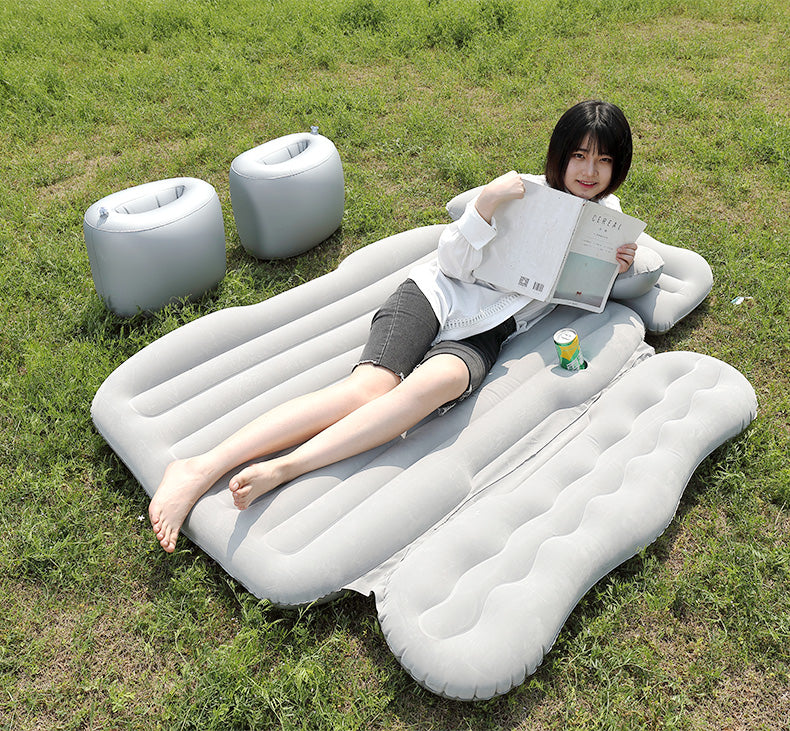 Person lying on an inflatable air bed in a grassy area