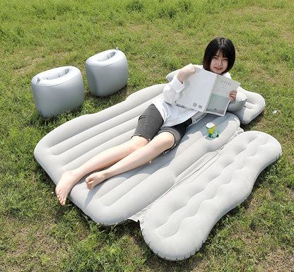 Person lying on an inflatable air bed in a grassy area
