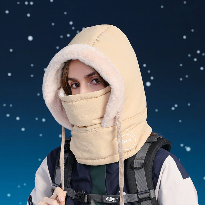 Person wearing a beige hood and balaclava against a snowy background