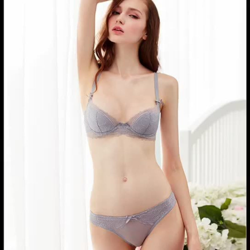 Woman wearing a gray bra and panties set against a white background with flowers.