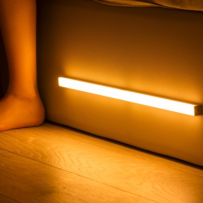 Light strip on a wooden floor with a foot in the background