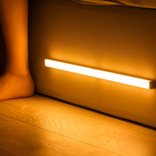 Light strip on a wooden floor with a foot in the background