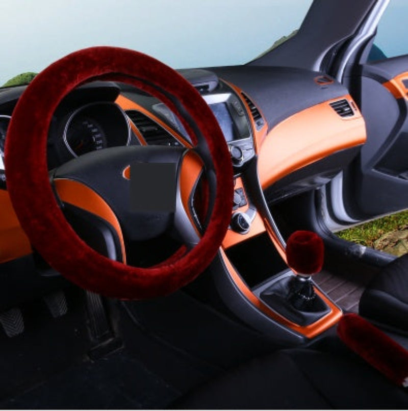 Car interior with a red steering wheel cover and orange dashboard.