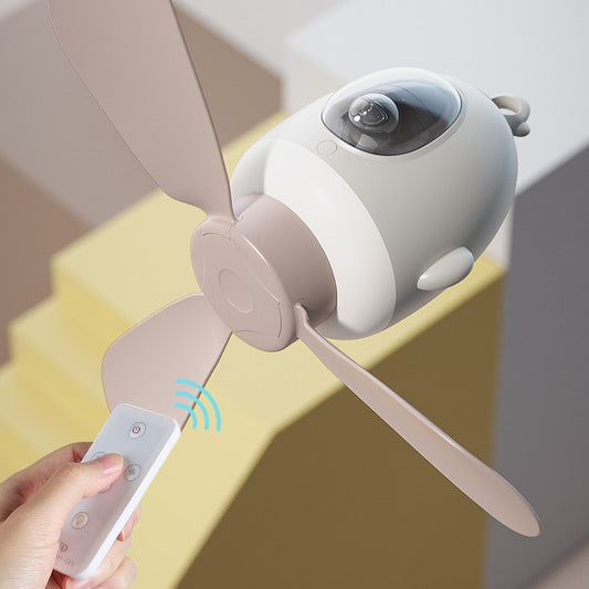 Handheld fan with remote control held by a hand against a neutral background