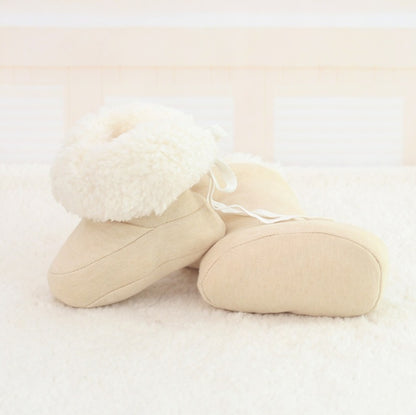 Beige slippers with fluffy white interior on a light background