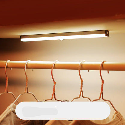 Under-cabinet light fixture above a clothing rack with hangers, labeled '300mm'.