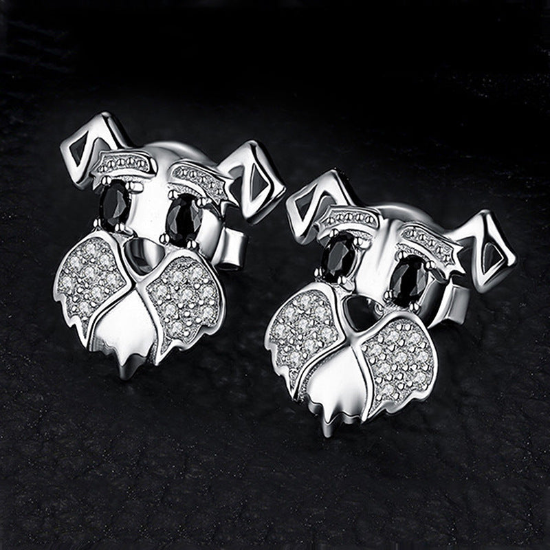 Pair of silver owl earrings with gemstones on a black background