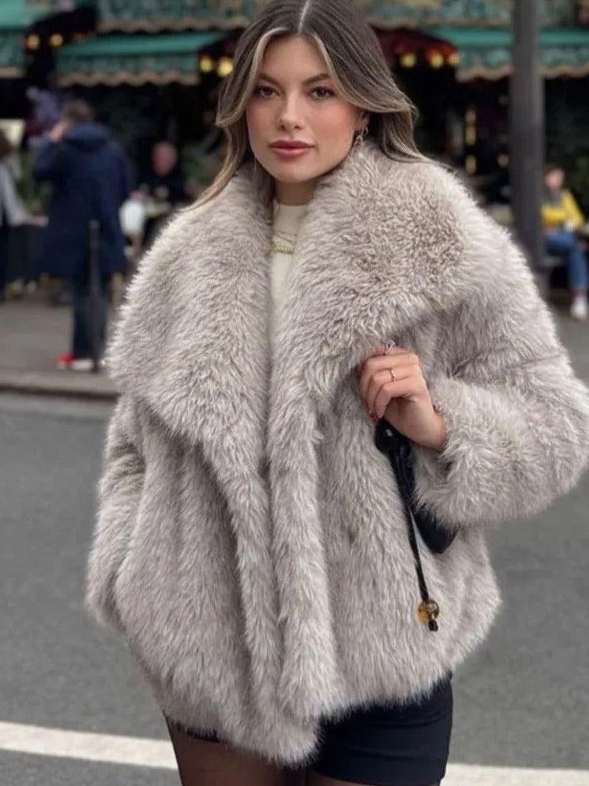 Woman wearing a fluffy gray coat on a street.