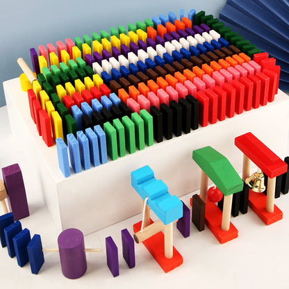 A set of colorful wooden domino blocks arranged in a variety of colors, with some dominoes standing upright and others laid down, indicating they have been used to build structures.
