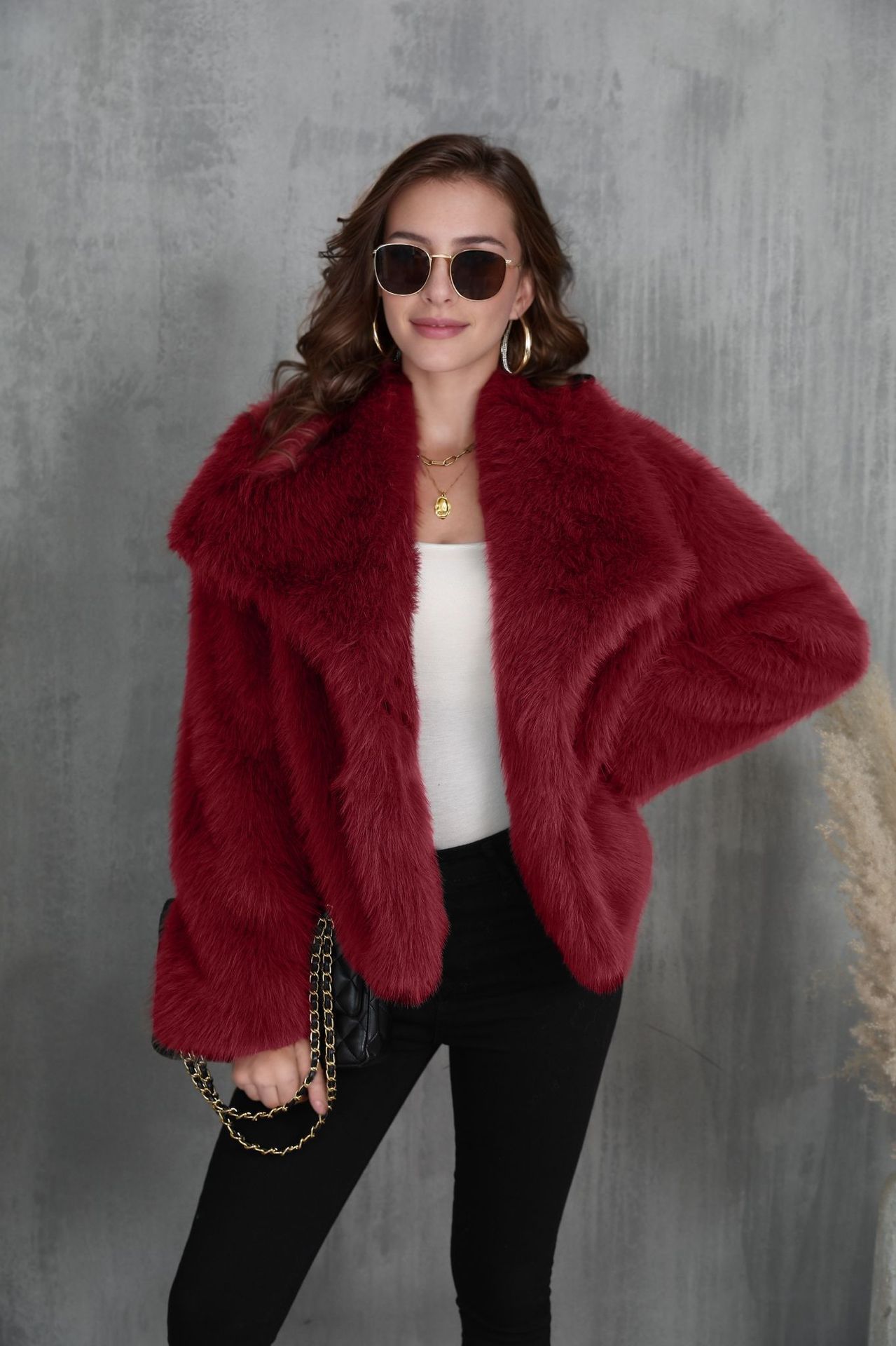 Woman wearing a red fur coat against a gray background