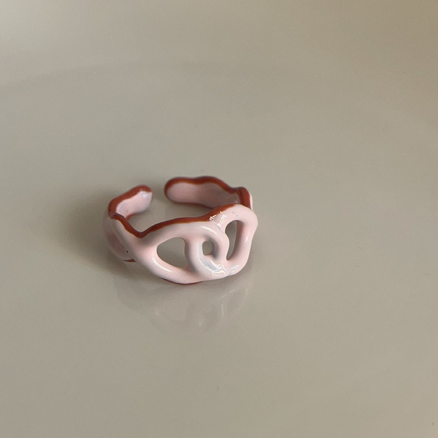 Pink adjustable ring on a beige background