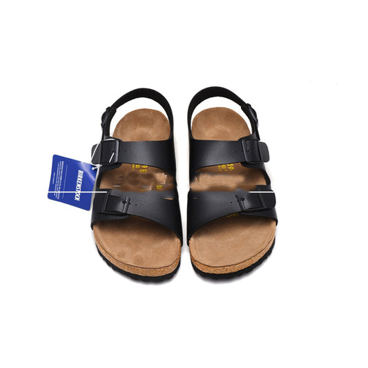 Pair of black sandals with brown soles on a white background