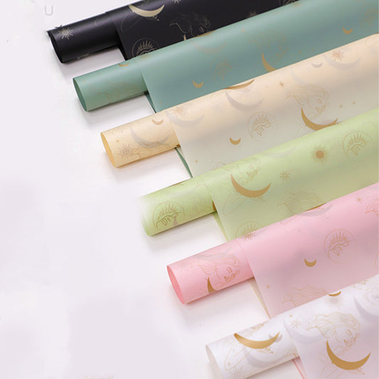 Rolls of decorative paper with celestial designs on a white background