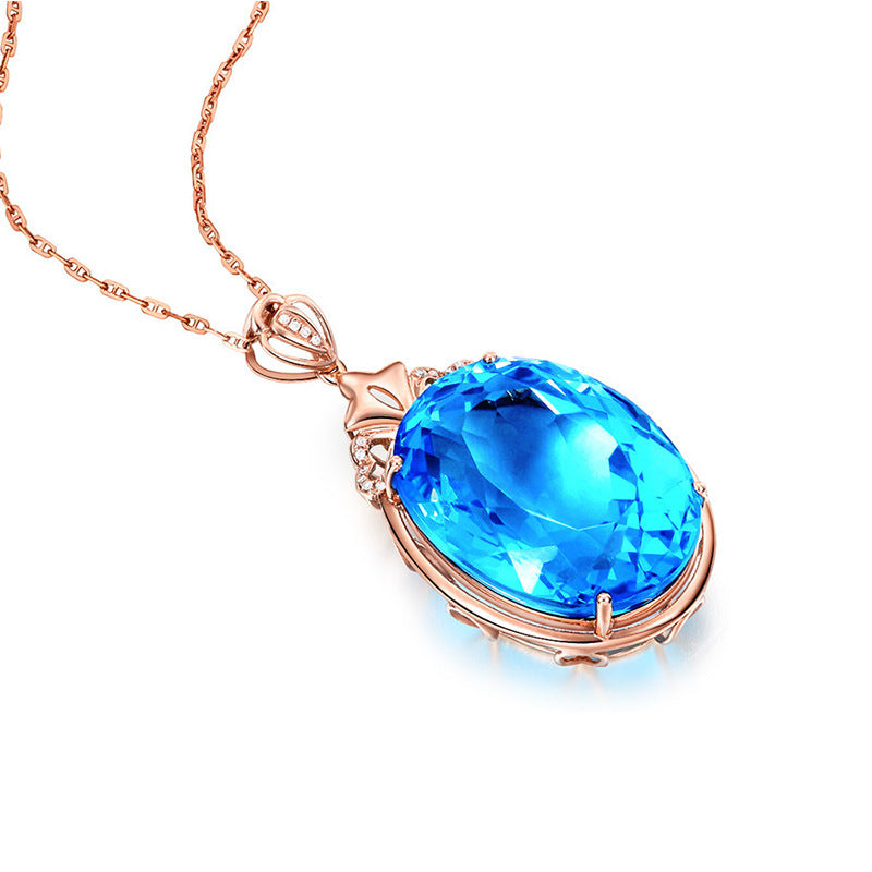 Rose gold necklace with a blue teardrop pendant on a white background
