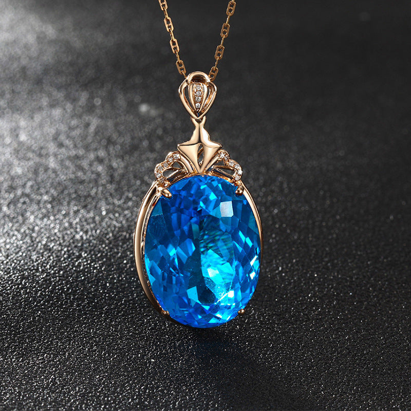 Gold pendant with a blue gemstone on a dark background