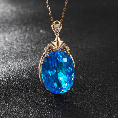 Gold pendant with a blue gemstone on a dark background