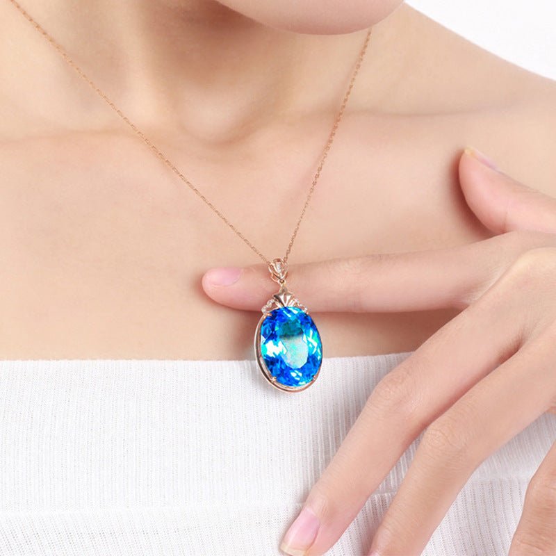 Necklace with a blue pendant worn by a person on a white background
