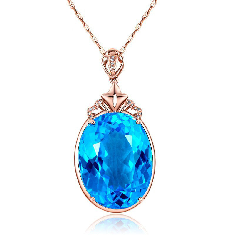 Rose gold necklace with a blue gemstone pendant on a white background