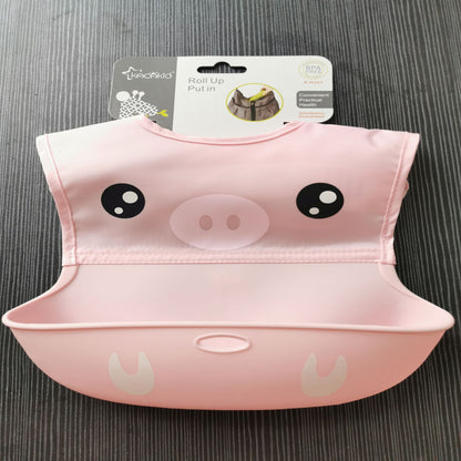 Pink animal-themed bib with a label on a gray surface