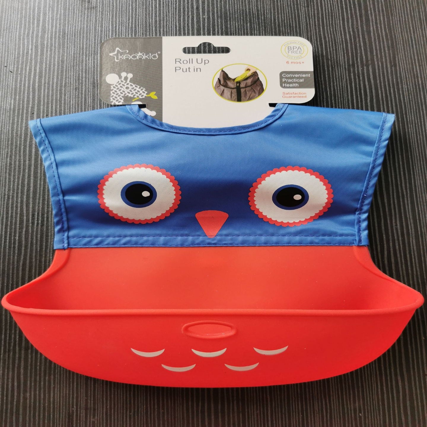 Blue and red bib with owl design on a gray surface