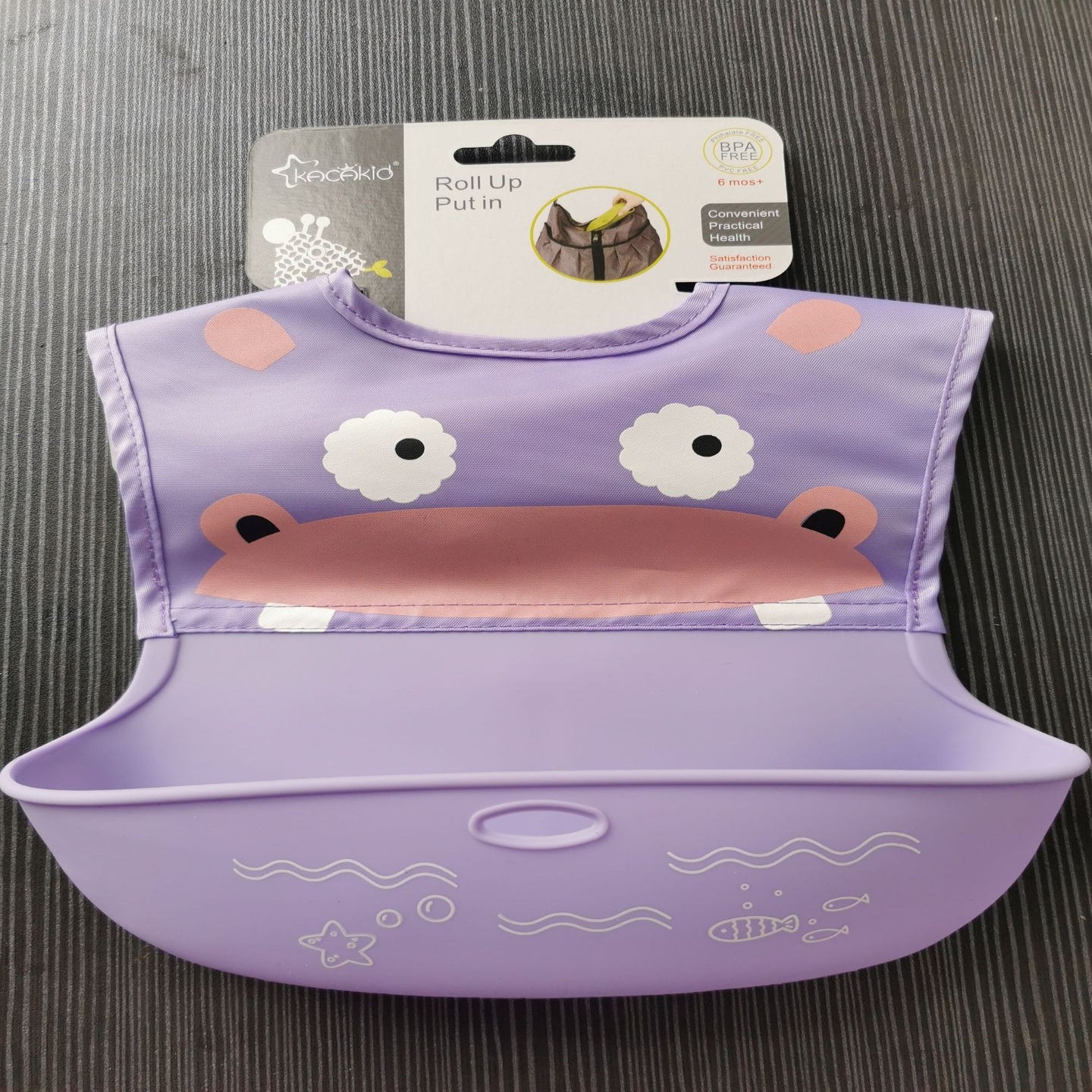 Purple children's bib with cartoon design on a gray surface