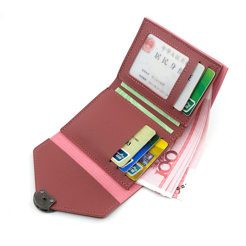 Pink wallet with various cards and a bill on a white background