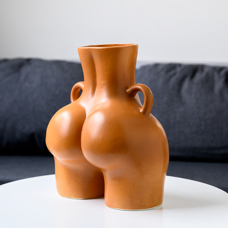Ceramic vase with a unique design on a white surface with a gray background