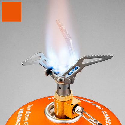 Portable camping stove with orange fuel canister on a gray background