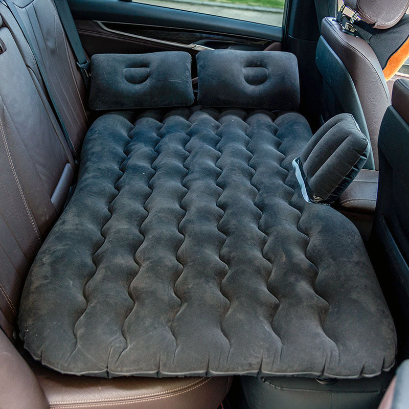 Inflatable mattress set up in the back of a car with airbed pump.