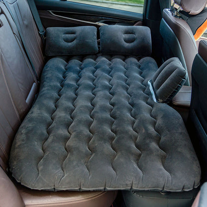 Inflatable mattress set up in the back of a car with airbed pump.