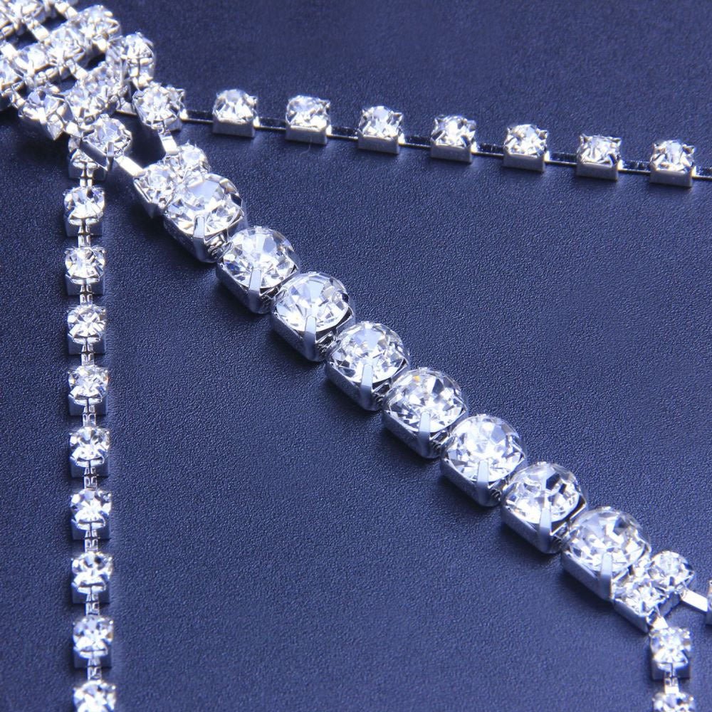A silver rhinestone body chain displayed on a mannequin's torso.