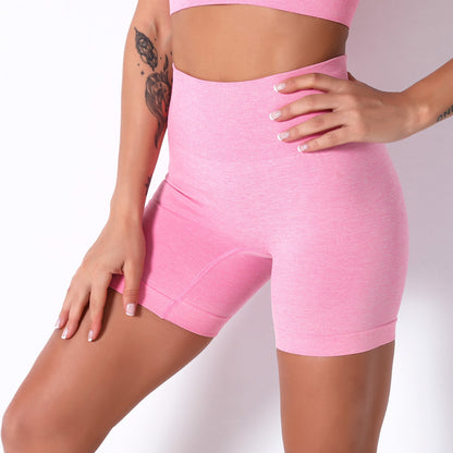 Person wearing pink athletic shorts on a plain background