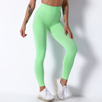 Person wearing bright green leggings on a white background
