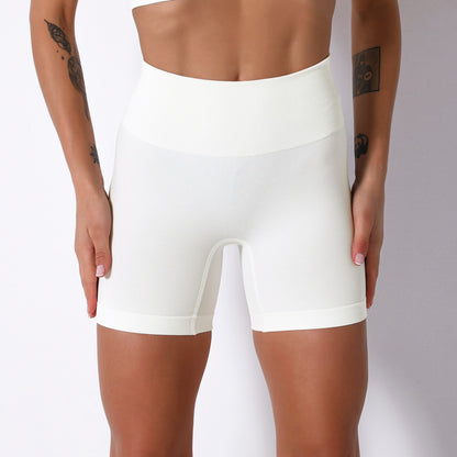White athletic shorts worn by a person on a plain background