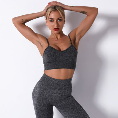 Woman wearing a gray sports bra and leggings against a white background
