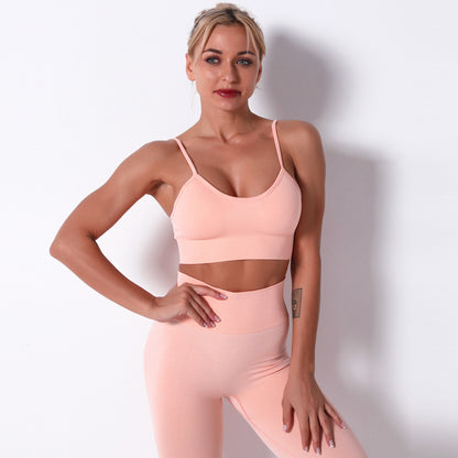 Woman wearing a pink sports bra and leggings against a white background