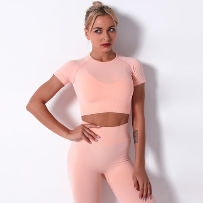 Woman wearing a pink athletic outfit against a white background