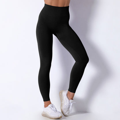 Person wearing black leggings and white sneakers on a plain background