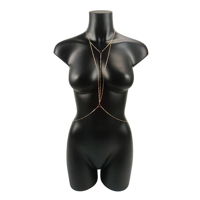 Gold body chain on black mannequin