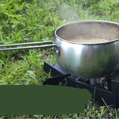 Stainless steel pot on a camping stove with grass in the background