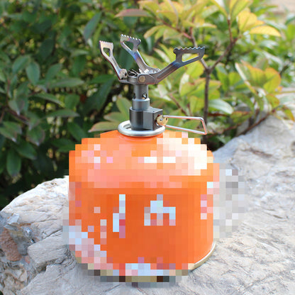 Orange camping stove on a stone surface with green foliage in the background