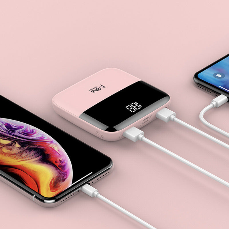 Pink power bank charging two smartphones on a pink background