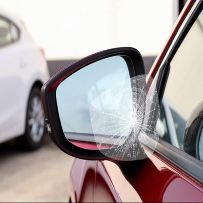 Broken car side mirror with a white car in the background