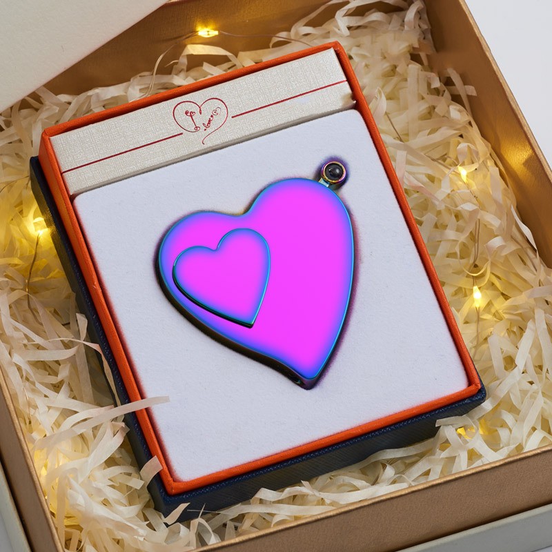 Heart-shaped purple pendant in a decorative box with white shreds and lights.