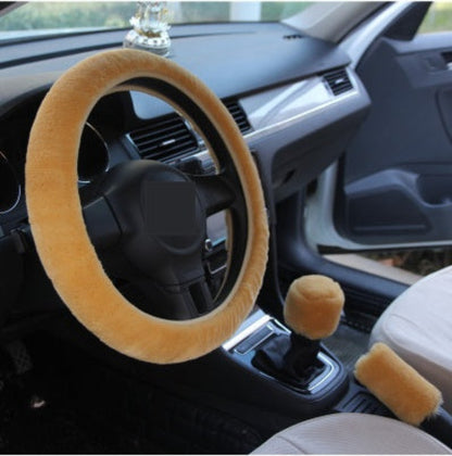 Car interior with a beige steering wheel cover and gear shift knob cover.