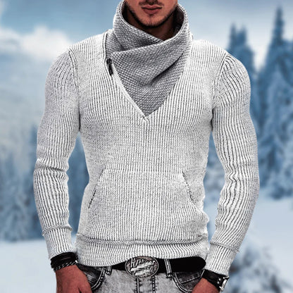 Person wearing a gray knitted sweater with a blurred snowy landscape in the background